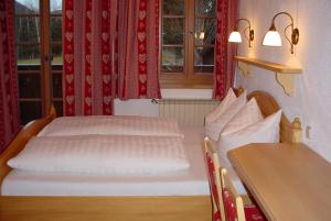een slaapkamer met 2 bedden en een tafel en ramen bij Kasparbauer in Sankt Michael im Lungau