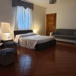 1 dormitorio con cama, sofá y ventana en Masseria La Rocca, en Pacentro