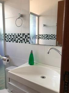un baño con lavabo y espejo en Residencial De Aluguel, en Bombinhas 97 fotos más