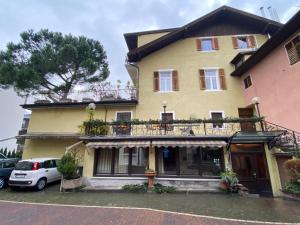 a yellow house with a balcony on top of it at Gasthof Albergo Ressmair in Merano