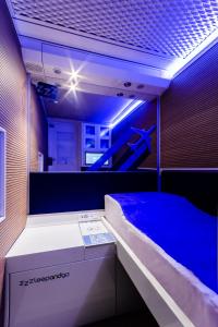 Cama en habitación con luz azul en Resting Pods - ZzzleepandGo VCE Venice Airport, en Tessera