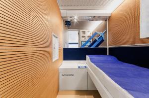 Piccola camera con letto e materasso blu di Resting Pods - ZzzleepandGo VCE Venice Airport a Tessera