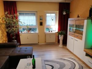 a living room with a couch and a kitchen with windows at Deichstube in Schweiburg