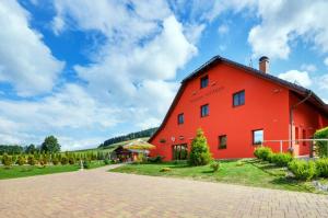 a red barn with a blue sky in the background at Penzion Ovčárna in Červená Voda