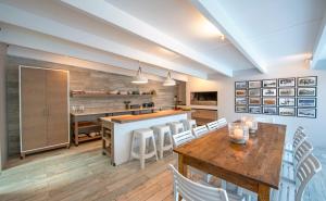 a kitchen with a wooden table and white chairs at Driftwood by The Oyster Collection in Kenton on Sea