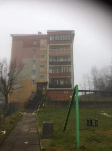 a tall building with a playground in front of it at Mieszkanie "Panorama" in Krynica Zdrój