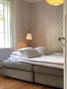 a bedroom with a bed with a lamp on it at Strandvillan Ljugarn in Ljugarn