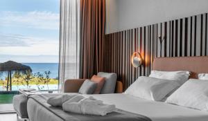 a hotel room with two beds and a view of the ocean at Hotel Verde Mar & SPA in Ribeira Grande