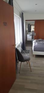 ein Schlafzimmer mit einem Bett und einem Stuhl in einem Zimmer in der Unterkunft Apotek Guesthouse in Höfn