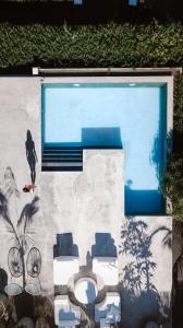 une peinture d'une piscine avec des chaises et une ombre dans l'établissement Hacienda El Socorro, à Los Realejos