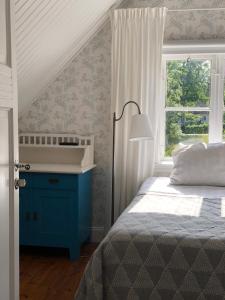 a bedroom with a blue bed and a window at Strandvillan Ljugarn in Ljugarn