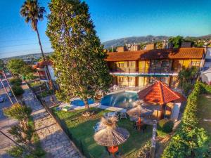 uma vista aérea de um hotel com uma piscina e guarda-sóis em Hotel Carlos Paz em Villa Carlos Paz