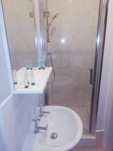 a bathroom with a white sink and a shower at The Lord Nelson in Brigg