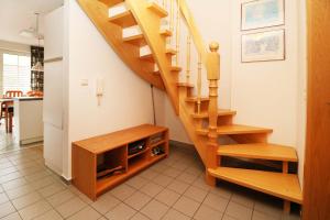 a wooden staircase in a living room next to a kitchen at Fewo Sommergarten 4022_CLEM in Ostseebad Karlshagen