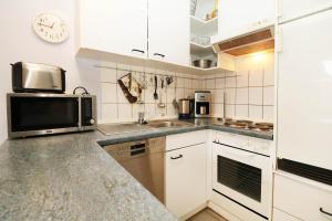 a kitchen with a microwave and a sink at Fewo Sommergarten 4022_CLEM in Ostseebad Karlshagen