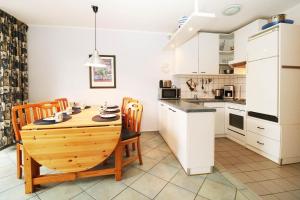 a kitchen and dining room with a wooden table and chairs at Fewo Sommergarten 4022_CLEM in Ostseebad Karlshagen