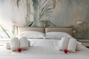 ein Bett mit weißen Handtüchern und roten Blumen darauf in der Unterkunft Palermo Blu - Palazzo Quaroni in Palermo
