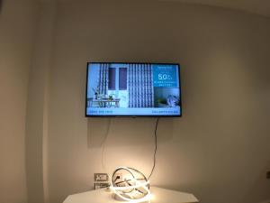 a flat screen tv hanging on a wall at Victoria Street Apartments in St. Albans