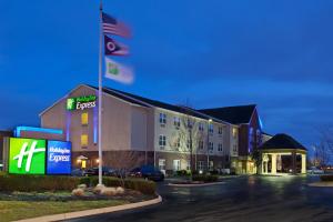 un hotel con bandera americana en un estacionamiento en Holiday Inn Express & Suites Columbus East - Reynoldsburg, an IHG Hotel, en Reynoldsburg