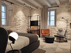 a bedroom with a bed and a desk and chairs at Zuviteo Residence in Korčula