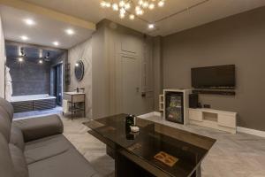 ein Wohnzimmer mit einem Sofa und einem TV in der Unterkunft Green Palace Hotel in Yerevan