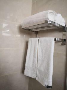 een badkamer met witte handdoeken op een handdoekenrek bij Walk In Hotel in Kota Kinabalu