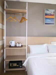 a bedroom with a bed and a shelf with hangers at Walk In Hotel in Kota Kinabalu