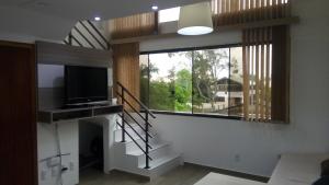 a living room with a staircase and a television at Loft torres Las piedras praia da Cal in Torres