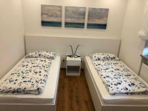 a room with two beds and a night stand at Ferber 28 in Monheim