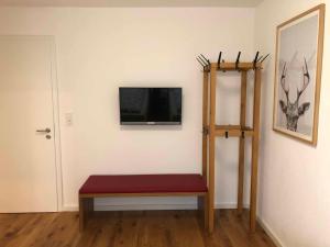 Zimmer mit einer Bank und einem TV an der Wand in der Unterkunft Ferber 28 in Monheim