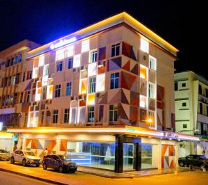 budynek z budynkiem z samochodami zaparkowanymi przed nim w obiekcie Walk In Hotel w mieście Kota Kinabalu