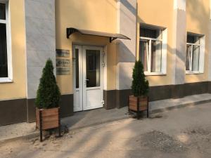 two potted trees sitting in front of a building at Pegas Club Hotel in Tula