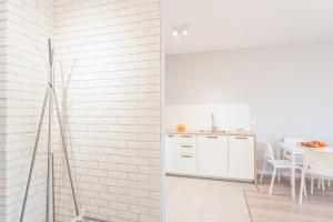 una cocina con una pared de ladrillo blanco en Chill Apartments Jana Kazimierza, en Varsovia