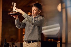 a man holding up a glass of wine at Boutique hotel Vila Planinka in Zgornje Jezersko