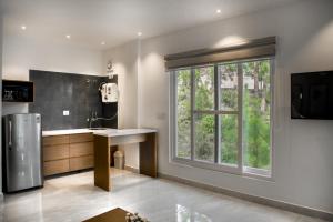 a kitchen with a sink and a large window at Hampstead Residences in Dagshai