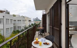 un balcón con una mesa con comida y bebidas. en Modern 2BR with MAMAD by HolyGuest en Tel Aviv