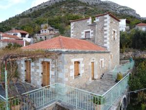 an old stone house with a mountain in the background at Nefeli in Tséria