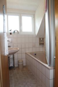 ein Badezimmer mit einer Badewanne und einem Waschbecken in der Unterkunft Ferienwohnung Schwarzwaldhof in Titisee-Neustadt