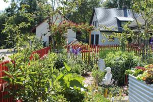 a garden in front of a house with a red fence at Ferienwohnung Schwarzwaldhof in Titisee-Neustadt +29 photos