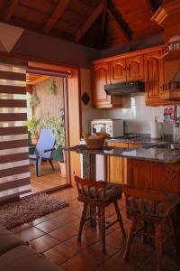 プンタゴルダにあるCasa Fagundoのキッチン(木製キャビネット、カウンター、椅子付)