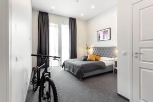 a bedroom with a bike parked next to a bed at Kaunas Garden in Kaunas