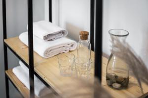 a shelf with glasses and bottles and towels at Kaunas Garden in Kaunas