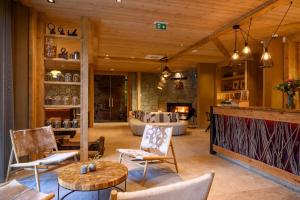 a living room with a couch and a table and chairs at Boutique hotel Vila Planinka in Zgornje Jezersko