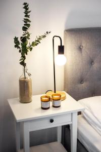 a white table with three candles on it next to a bed at Kaunas Garden in Kaunas