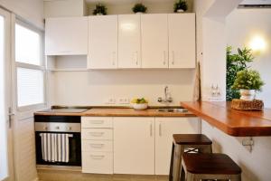 cocina con armarios blancos y encimera de madera en Sea House Can Picafort en Can Picafort