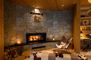 a living room with a stone wall with a fireplace at Boutique hotel Vila Planinka in Zgornje Jezersko