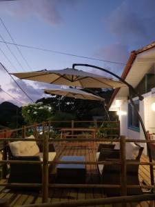 a patio with an umbrella and couches on a deck at Oceano Azul Noronha in Fernando de Noronha