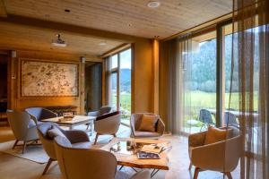 a room with tables and chairs and a large window at Boutique hotel Vila Planinka in Zgornje Jezersko