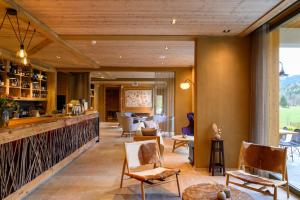 a lobby of a hotel with chairs and a bar at Boutique hotel Vila Planinka in Zgornje Jezersko