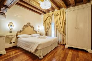 a bedroom with a large bed in a room with wooden floors at Hotel Vecellio Venice on the Lagoon in Venice